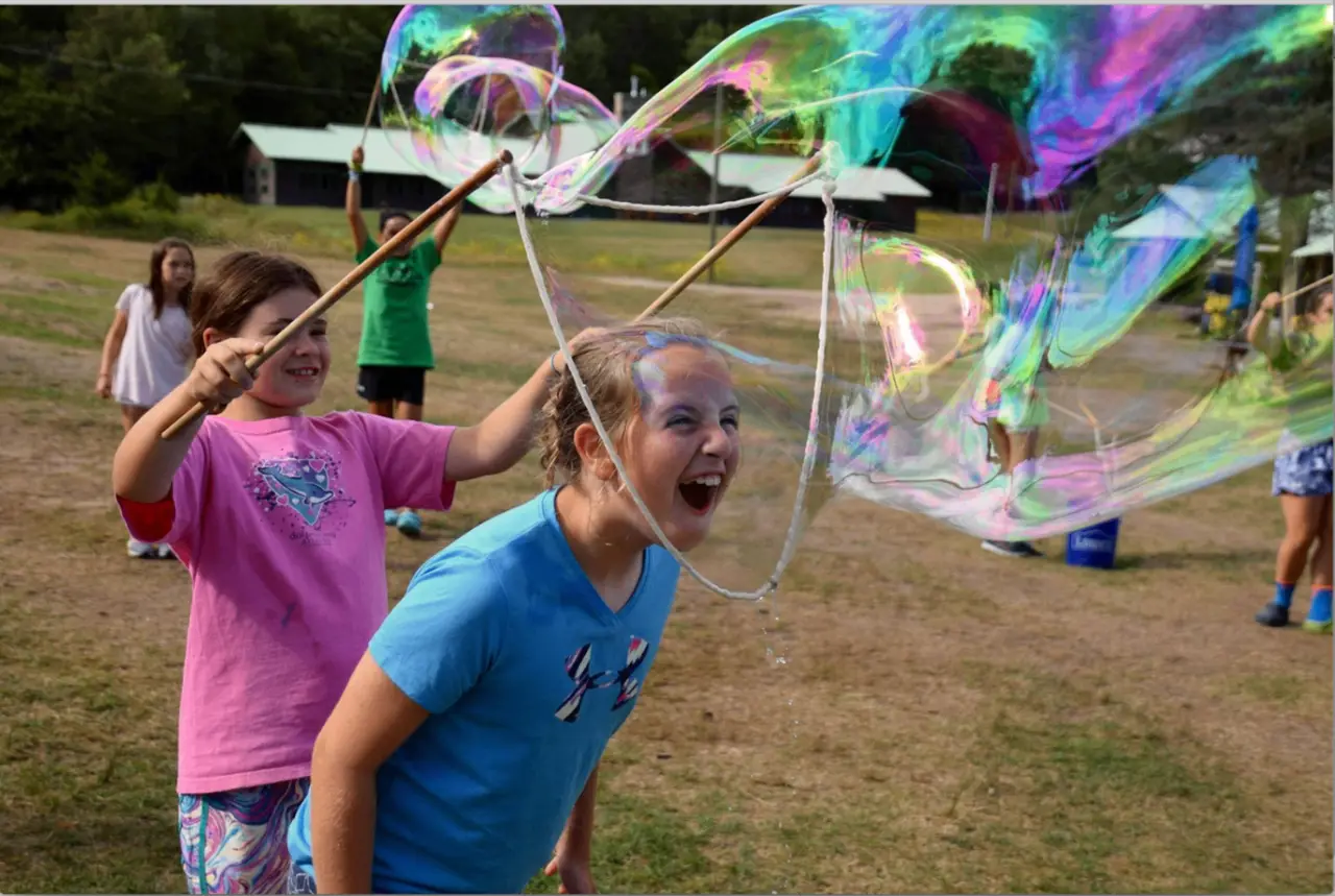 Kids making giant bubbles together at a private party