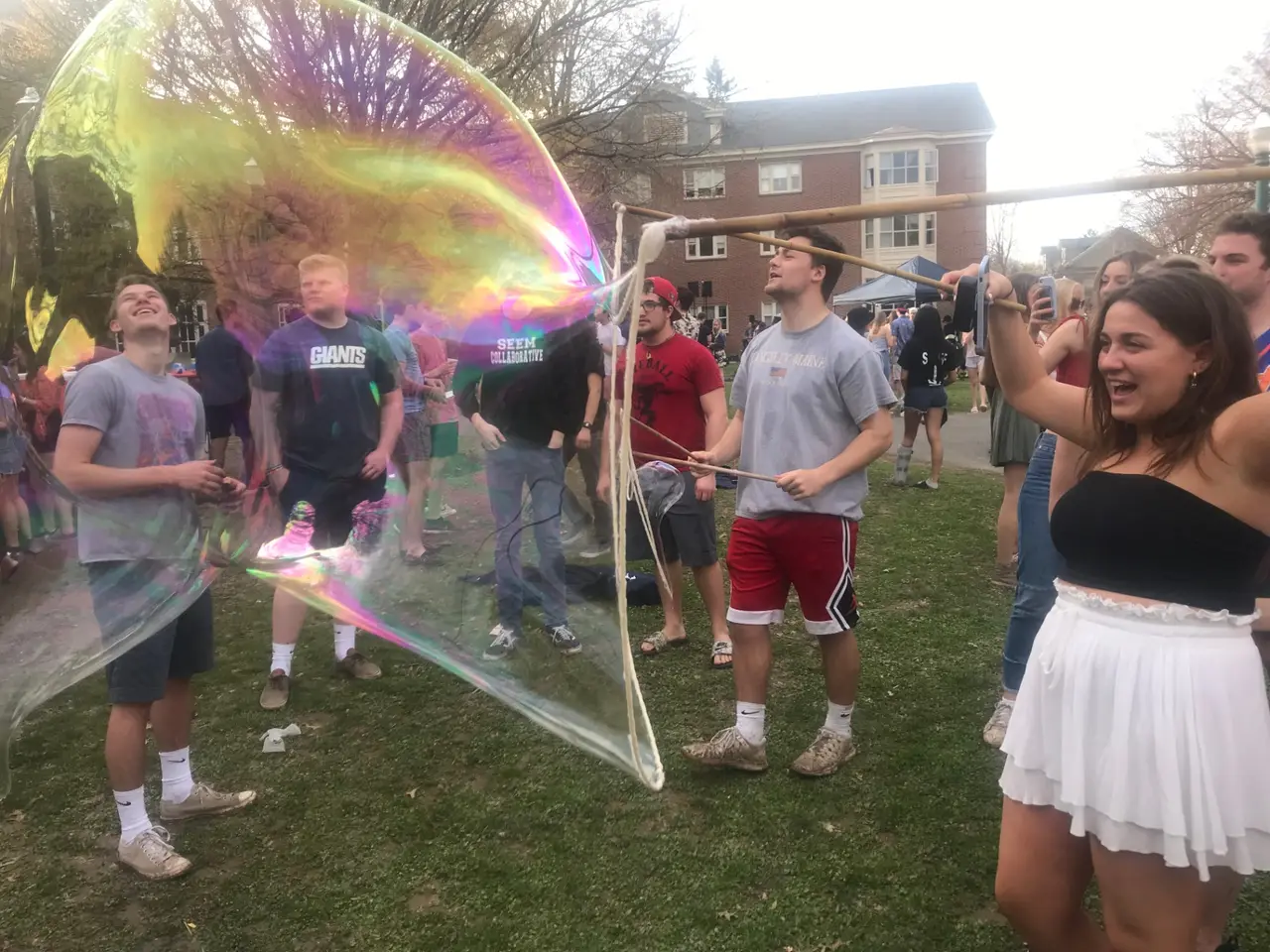 College campus bubble activation with students gathered around giant iridescent bubbles