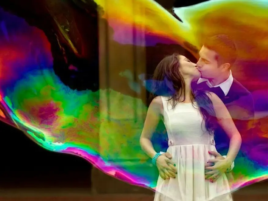 Engagement photoshoot featuring a couple inside a giant iridescent bubble