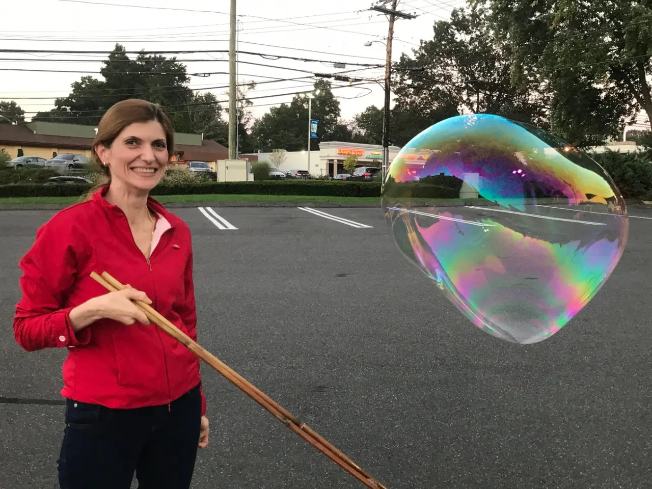 Central Park Bubbles artist sculpting a giant iridescent bubble live for an audience